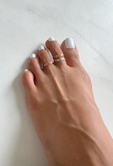 Foot model wearing 14K Rose-Gold Filled Adjustable Overlap mini Toe Ring. Slightly hammered to give texture and style.