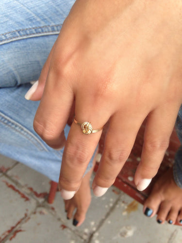 Handcrafted high gloss dainty ring is formed by two bands that are hand twisted into a tightly wrapped knot. Looks great worn alone or even better with other rings.