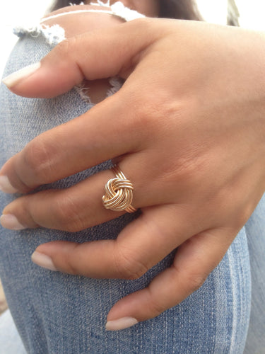 Handcrafted high gloss and dainty ring is formed with three bands that are hand twisted into a tightly wrapped knot. Looks great worn alone or even better with other rings. The ring can also be worn as a mid-ring. It measures 13 x 12mm and is available in 14K yellow gold-filled, 14K rose gold-filled & sterling silver.