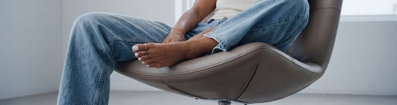 feet with white pedicure wearing minimalist silver toe rings