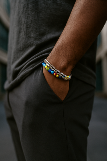 Person wearing colorful beaded bracelets on a blurred background