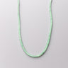 A single strand of 4mm mint green aventurine heishi beads displayed in a U-shape against a neutral light grey background.
