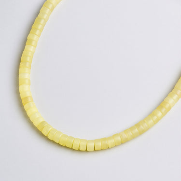 A macro close-up view highlighting the unique disc-shaped lemon jade beads and their natural soft yellow color consistency.
