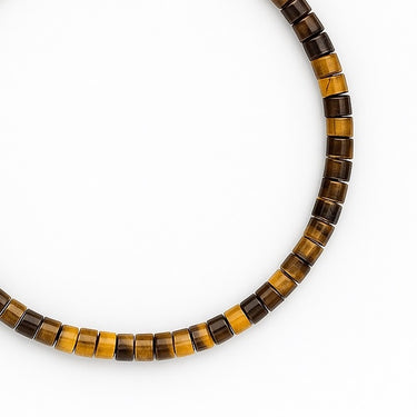 A close-up hero shot of the 4mm tiger's eye heishi bracelet, emphasizing the high-polish finish of the 14K gold-filled hardware and the organic banding of the natural gemstones.
