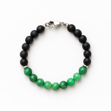 Bracelet with black and green beads on a white background