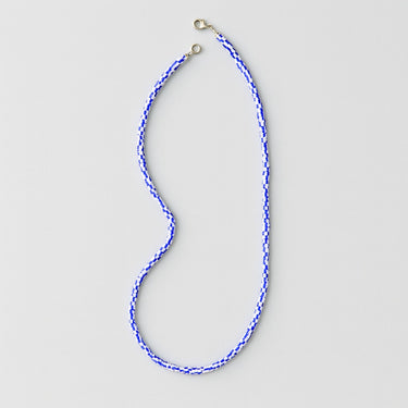 Blue beaded necklace on a light gray background