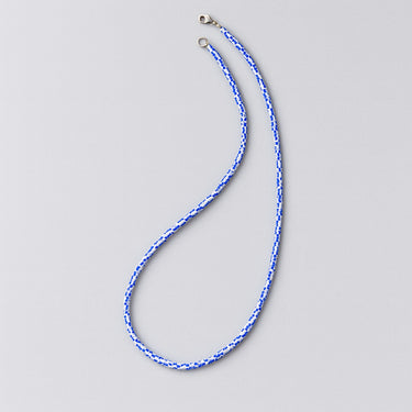 Blue and white beaded lanyard on a light gray background