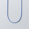 Blue and white braided necklace on a gray background