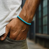 Person wearing a turquoise bracelet on a blurred background
