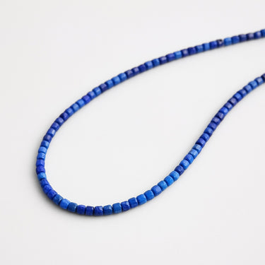Product shot of a blue lapis lazuli  beaded necklace on a white background