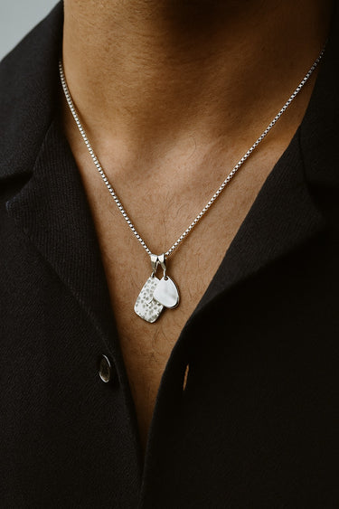 mens silver amulet pendant necklace styled on model with open collar shirt modern minimalist look