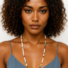 Woman wearing a colorful beaded necklace against a plain background