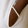 Pearl bracelet on a wrist with a white garment