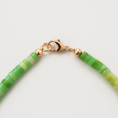 Close-up of the 14K gold-filled lobster clasp on African Green Chrysoprase bead necklace on a light background