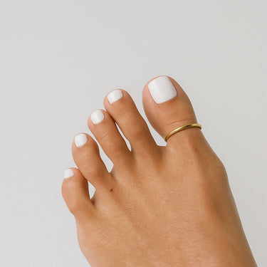 Side angle of gold anodized aluminum big toe ring — lightweight water-friendly design, Clay & Chloe Jewelry.
