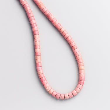 A top-down perspective of the pink petrified rhodonite necklace, emphasizing the industrial-refined edge and tactile, matte texture of the heishi beads.

