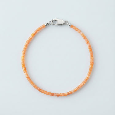 A 2mm faceted Golden Sunstone cube bead bracelet with a high-polish silver lobster clasp, highlighting the light-reflecting geometric facets.
