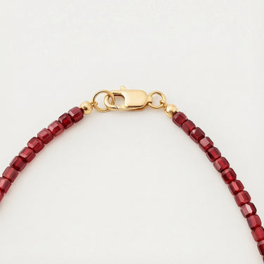 Close-up of a men’s necklace with 3mm faceted red garnet beads and a polished 14K gold-filled lobster clasp.