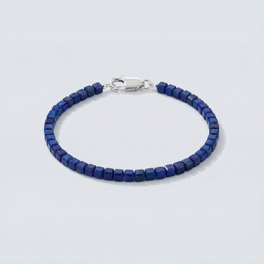 An angled editorial view of a 3mm faceted Lapis Lazuli cube bracelet highlighting the light-reflecting geometric surfaces and silver clasp.

