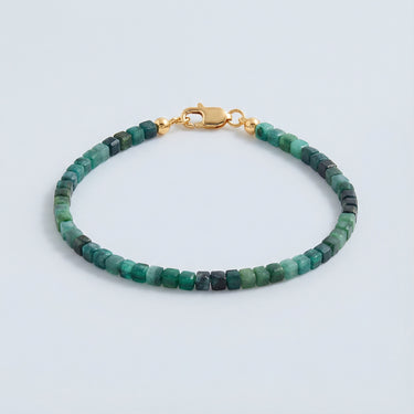 A 3mm faceted tourmaline cube bead bracelet featuring deep green tones and a high-polish gold lobster clasp.
