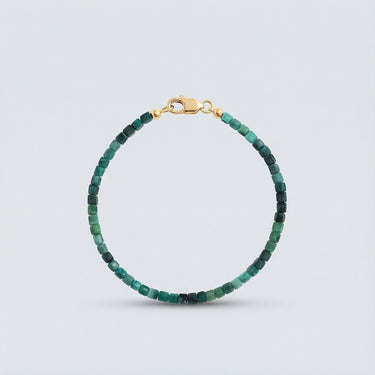An angled editorial view of a 3mm faceted tourmaline cube bracelet highlighting the light-reflecting geometric surfaces.
