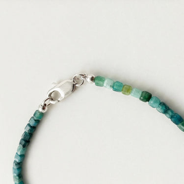 Close-up of a men’s necklace with 3mm faceted tourmaline beads and a polished sterling silver lobster clasp.