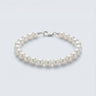 A 4-5mm white baroque freshwater pearl bracelet featuring unique organic shapes and a high-polish silver lobster clasp, displayed against a light grey background.
