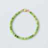 A 4mm African green chrysoprase heishi bead bracelet with a high-polish gold lobster clasp, displayed against a light grey background.
