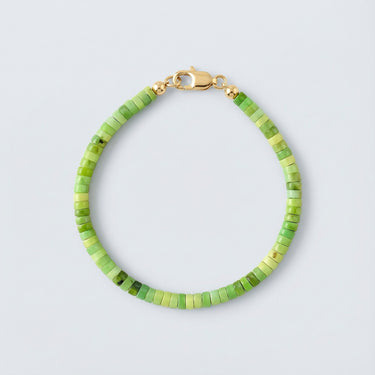 A 4mm African green chrysoprase heishi bead bracelet with a high-polish gold lobster clasp, displayed against a light grey background.

