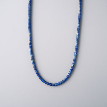 Front view of a men’s necklace featuring 4mm deep blue lapis heshi beads on a white background.
