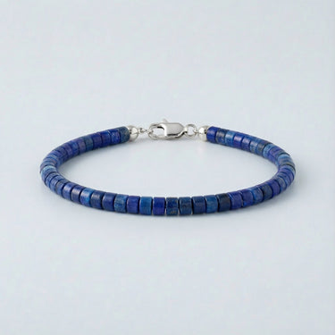 A 4mm Lapis Lazuli heishi bead bracelet with a high-polish silver lobster clasp, displayed against a light grey background.

