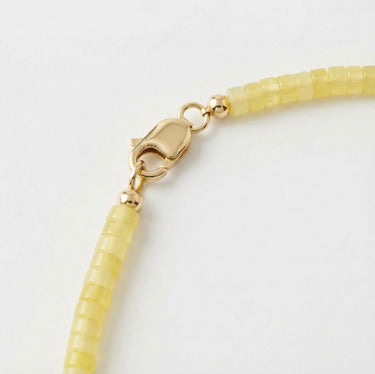 Close-up of a men’s necklace with 4mm lemon jade heshi beads and a polished 14K gold-filled lobster clasp.