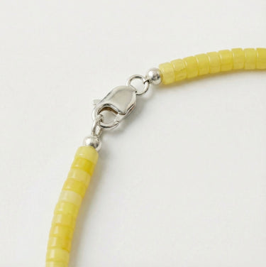 Close-up of a men’s necklace with 4mm lemon jade heshi beads and a polished sterling silver lobster clasp.