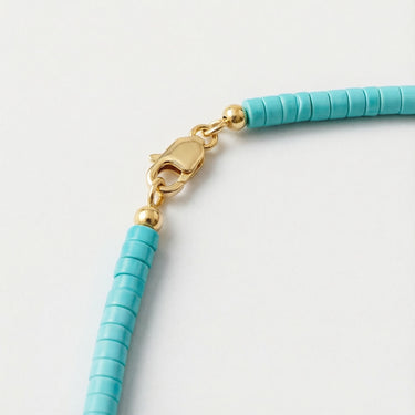Close-up of a men’s 4mm turquoise heshi necklace featuring a polished 14K gold-filled lobster clasp.
