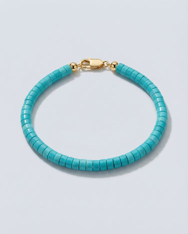 An angled editorial view of a 4mm turquoise heishi bead bracelet highlighting the smooth, architectural disc shape.
