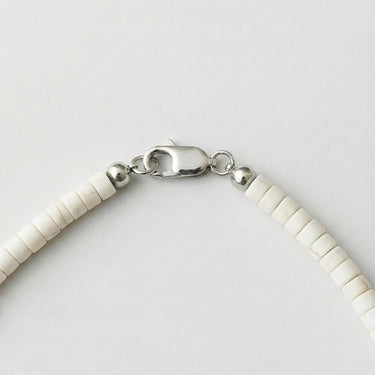 Close-up of a men’s necklace with 4mm white turquoise heshi beads and a polished sterling silver lobster clasp.