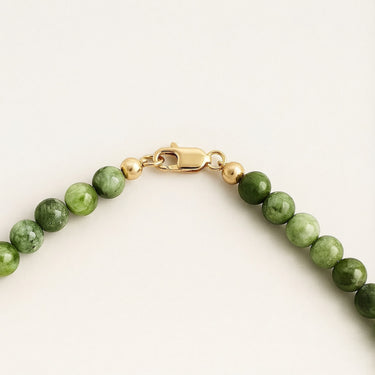Close-up of a men’s necklace with 6mm green chrome diopside beads and a polished 14K gold-filled lobster clasp.