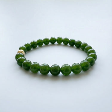 A top-down view of a 6mm jade bead bracelet, showcasing the consistent color and quality of the green gemstones.
