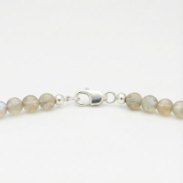 Close-up of a men’s necklace with 6mm labradorite beads and a polished sterling silver lobster clasp.