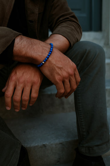 A lifestyle shot of a male model wearing a 6mm Blue Lapis Lazuli bracelet, showcasing its rich pigment and slim, versatile profile.
