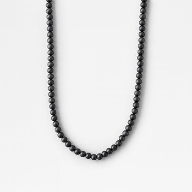A single strand of 6mm matte black onyx beads displayed in a U-shape against a bright white background.
