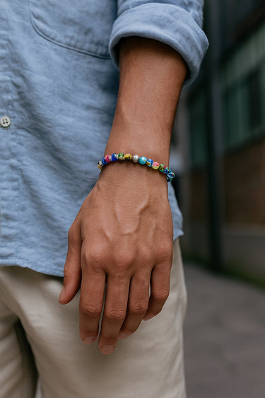 A close-up of a male model's wrist showcasing the intricate, colorful floral details of a 6mm Millefiori glass bead bracelet.
