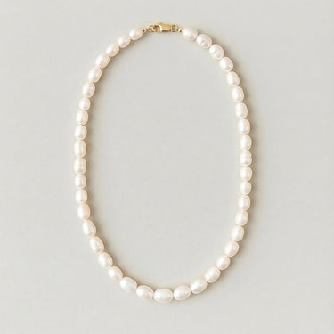 Full view of a men's 7-8mm freshwater pearl beaded necklace arranged in an oval on a light gray studio background.