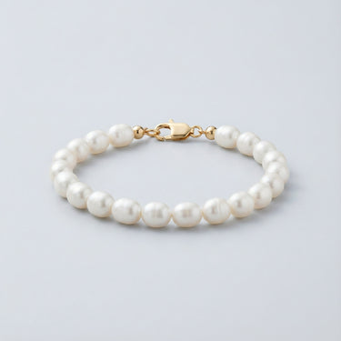 A 7-8mm white baroque freshwater pearl bead bracelet featuring a high-polish gold lobster clasp, displayed against a light grey background.
