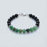 An 8mm bead bracelet featuring vibrant green Emerald center beads and matte black onyx round beads with a high-polish silver lobster clasp.
