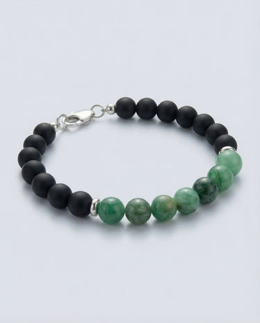 An angled editorial view of an 8mm Emerald and Onyx bead bracelet highlighting the natural stone textures and polished silver hardware.
