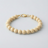 An 8mm Fossil Jasper round bead bracelet featuring natural earthen-toned patterns and a high-polish gold lobster clasp.
