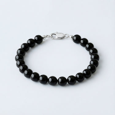 An 8mm Gloss Black Onyx round bead bracelet featuring a high-polish silver lobster clasp, emphasizing a clean, monochromatic look.
