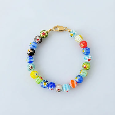 An 8mm handmade Millefiori glass bead bracelet featuring a kaleidoscope of floral patterns and a high-polish gold lobster clasp.
