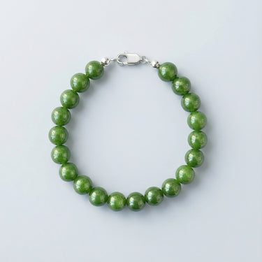 An 8mm green jade round bead bracelet with a high-polish silver lobster clasp, highlighting the natural stone texture.
